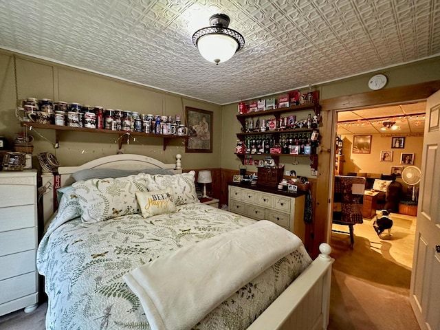 bedroom with an ornate ceiling and wainscoting