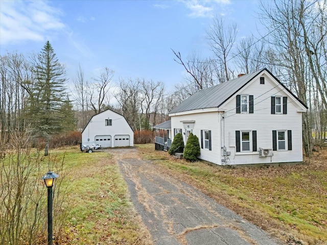 view of home's exterior featuring an outbuilding, metal roof, and a garage