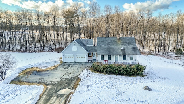 cape cod house with aphalt driveway, a porch, and a garage