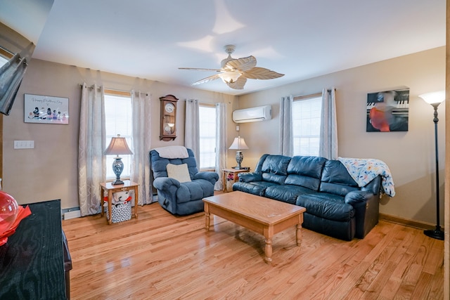 living area featuring a wall mounted air conditioner, baseboards, light wood-style floors, and ceiling fan