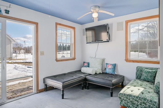 living area with concrete floors and a ceiling fan