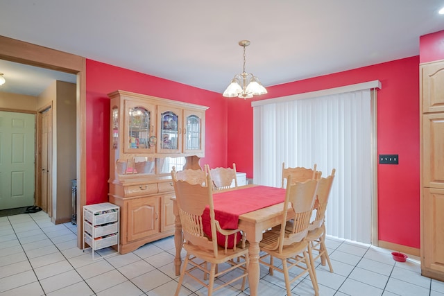 dining space with a notable chandelier, light tile patterned floors, and baseboards