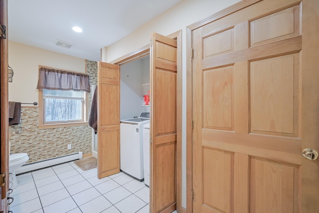 interior space with a baseboard heating unit, light tile patterned floors, and light brown cabinetry