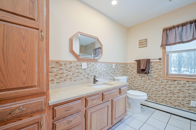 bathroom featuring tile patterned flooring, toilet, vanity, tile walls, and a baseboard radiator