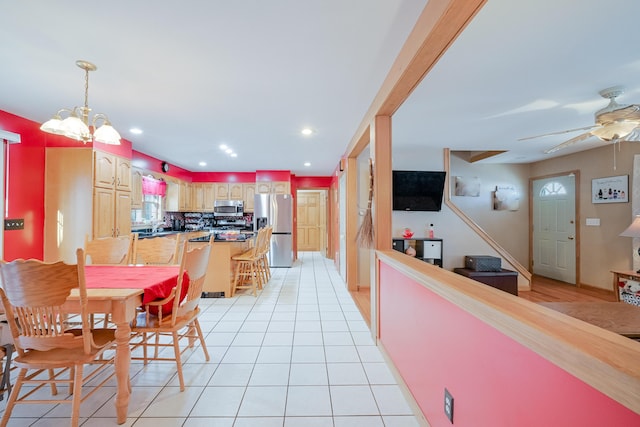 dining area with ceiling fan with notable chandelier, light tile patterned floors, and recessed lighting