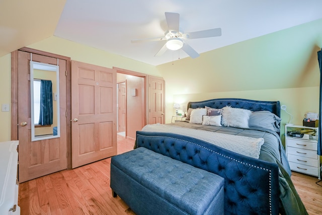 bedroom with vaulted ceiling, light wood-style flooring, and a ceiling fan