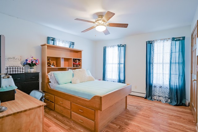 bedroom with ceiling fan, light wood-style floors, and a baseboard radiator