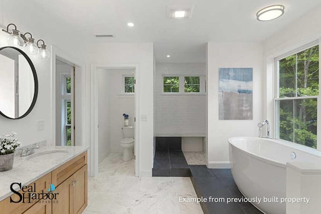 11 Clam Ln Unit A, Wells, ME 04090 - full bathroom featuring toilet, healthy amount of natural light, a freestanding tub, vanity, and recessed lighting