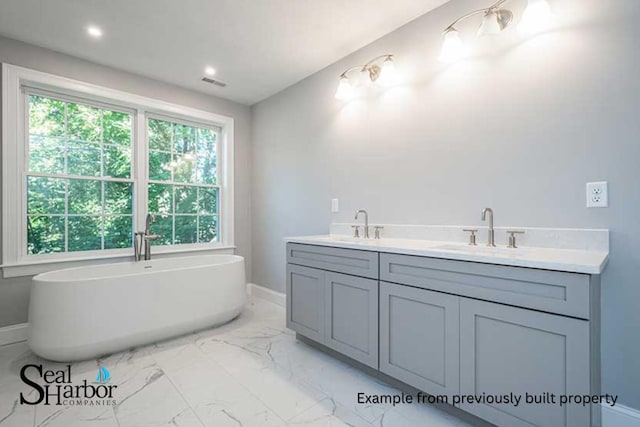 11 Clam Ln Unit A, Wells, ME 04090 - bathroom featuring baseboards, marble finish flooring, a soaking tub, and double vanity