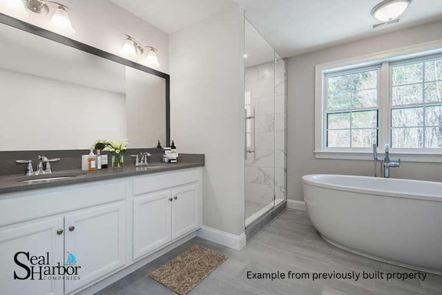11 Clam Ln Unit A, Wells, ME 04090 - full bath with baseboards, a shower stall, a freestanding tub, and double vanity