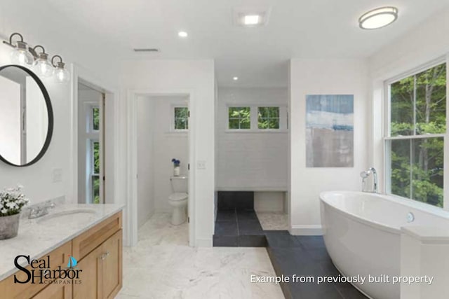 11 Clam Ln Unit A, Wells, ME 04090 - full bathroom featuring toilet, a freestanding bath, vanity, recessed lighting, and baseboards
