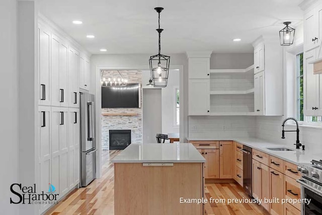 11 Clam Ln Unit A, Wells, ME 04090 - kitchen with appliances with stainless steel finishes, open shelves, a sink, light wood-style flooring, and a center island