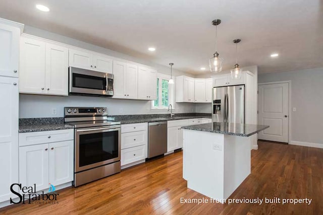 11 Clam Ln Unit A, Wells, ME 04090 - kitchen with appliances with stainless steel finishes, white cabinetry, recessed lighting, decorative light fixtures, and a center island