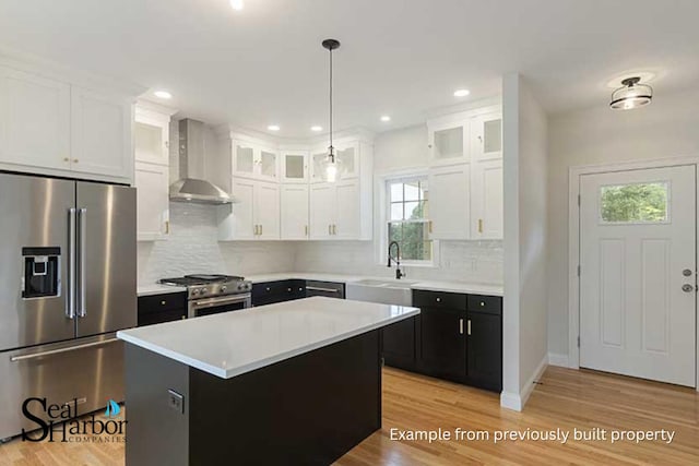 11 Clam Ln Unit A, Wells, ME 04090 - kitchen featuring high end appliances, wall chimney range hood, white cabinetry, light countertops, and backsplash