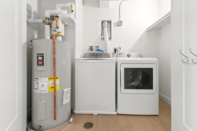 laundry room featuring washer and dryer, laundry area, light wood-type flooring, and electric water heater