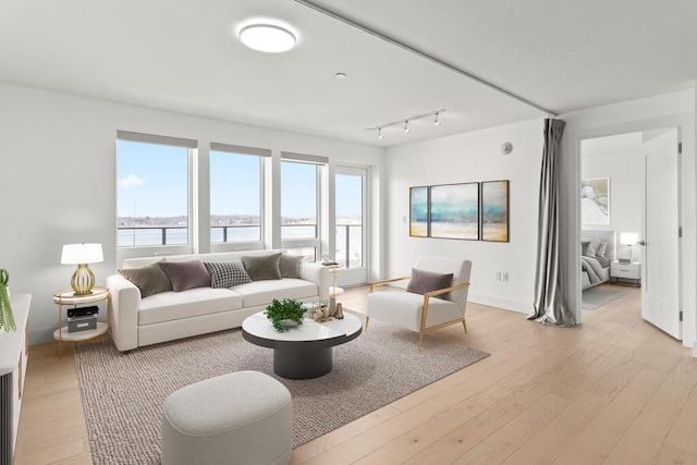 living area featuring light wood-style flooring and baseboards