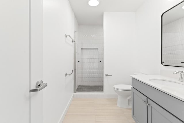 full bath with tile patterned flooring, baseboards, toilet, a tile shower, and vanity