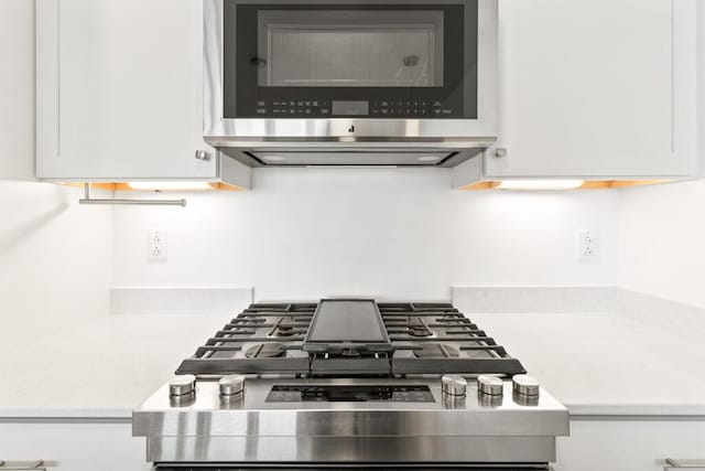 interior details with light countertops, white cabinets, and stainless steel appliances