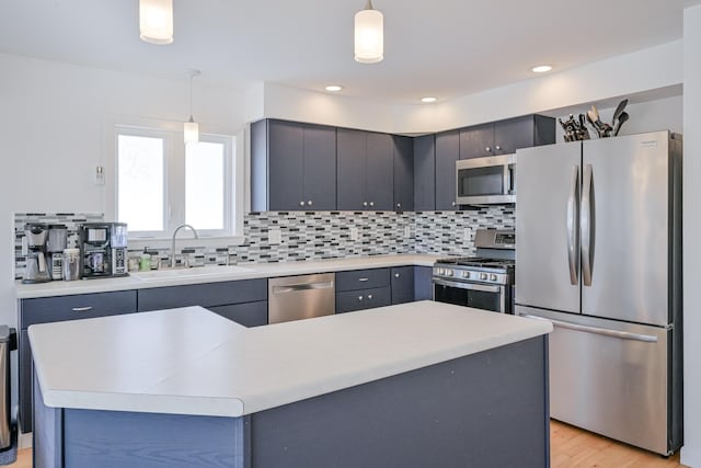 kitchen featuring a sink, decorative backsplash, light countertops, and stainless steel appliances