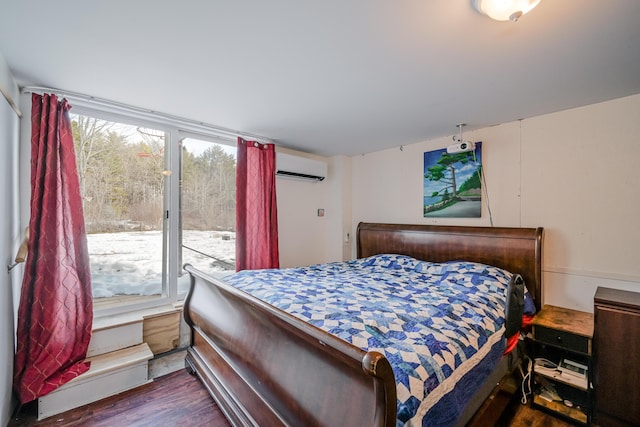 bedroom with access to exterior, an AC wall unit, and wood finished floors