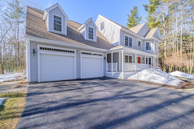 view of front of property featuring aphalt driveway, covered porch, an attached garage, and roof with shingles