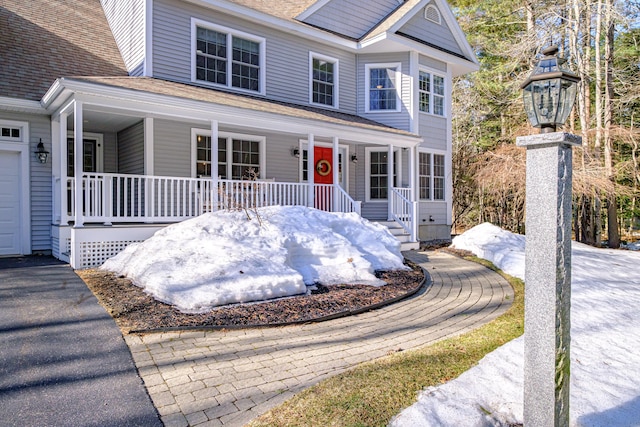 view of front of house featuring covered porch and a shingled roof