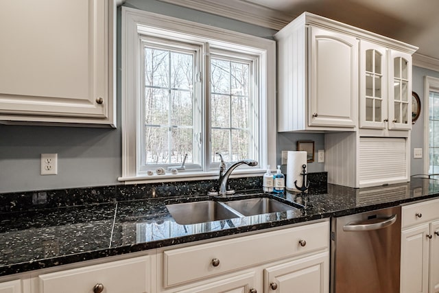 kitchen featuring dishwasher, dark stone counters, glass insert cabinets, and a sink