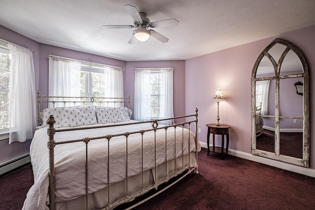 carpeted bedroom with ceiling fan, a textured ceiling, a baseboard heating unit, and baseboards