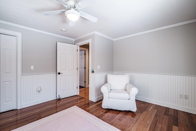 bedroom featuring ceiling fan, wood finished floors, wainscoting, and crown molding