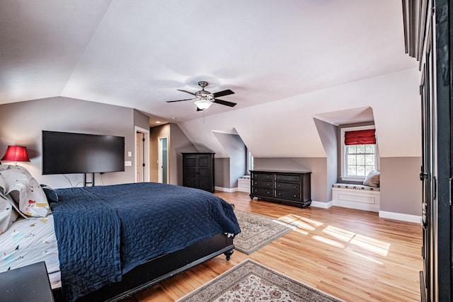 bedroom with a ceiling fan, lofted ceiling, wood finished floors, and baseboards