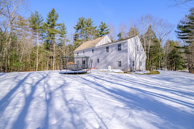 snow covered house featuring a trampoline