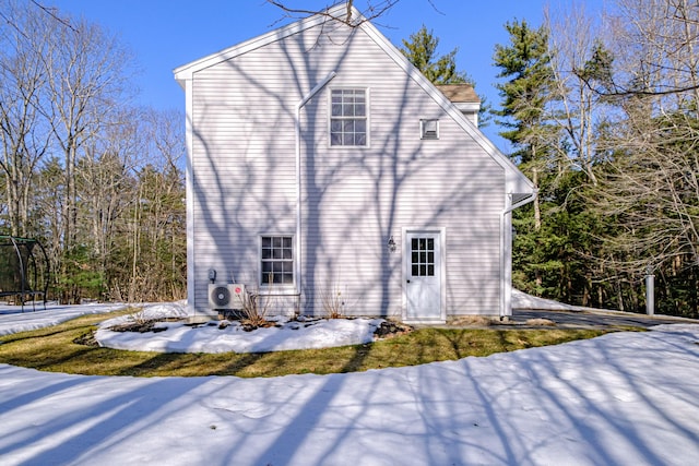 snow covered property with ac unit