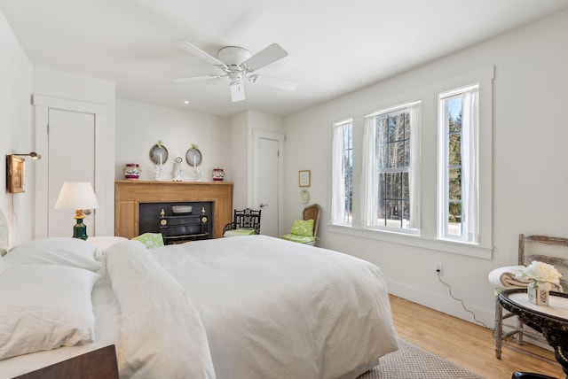 135 P Ridge Rd, Readfield, ME 04355 - bedroom with light wood-type flooring, a fireplace, baseboards, and ceiling fan