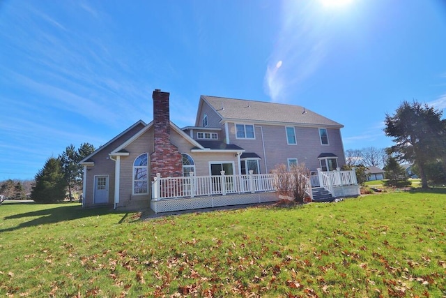 back of house featuring a deck, a lawn, and a chimney