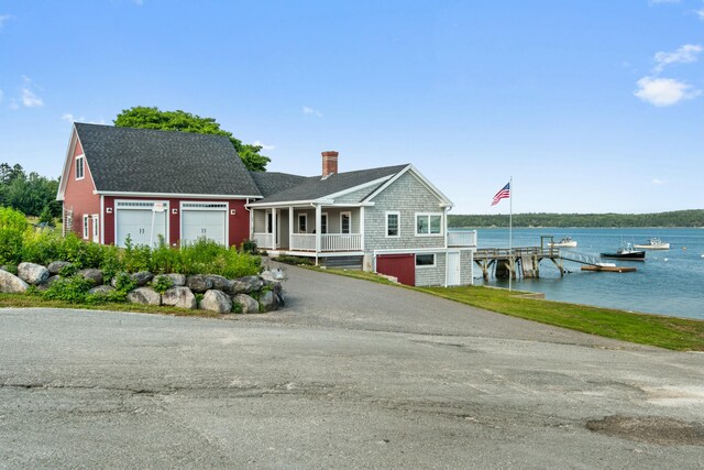 20 Wharf Rd, Blue Hill, ME 04614 - view of front of home with a chimney, a water view, a shingled roof, asphalt driveway, and an attached garage