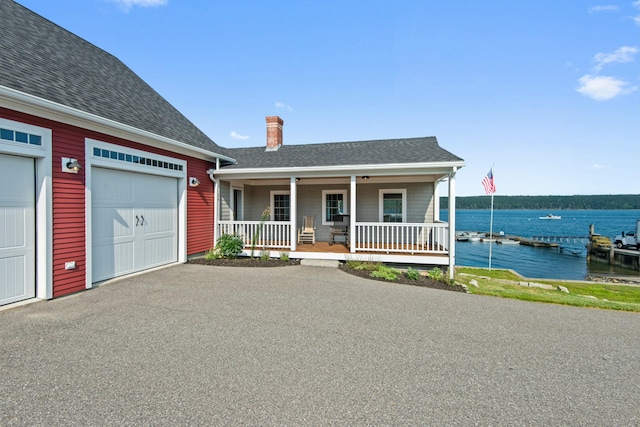 20 Wharf Rd, Blue Hill, ME 04614 - single story home featuring a water view, a chimney, a porch, roof with shingles, and an attached garage