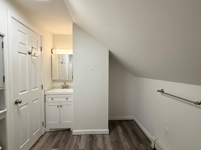 bathroom featuring vanity, wood finished floors, baseboards, vaulted ceiling, and baseboard heating