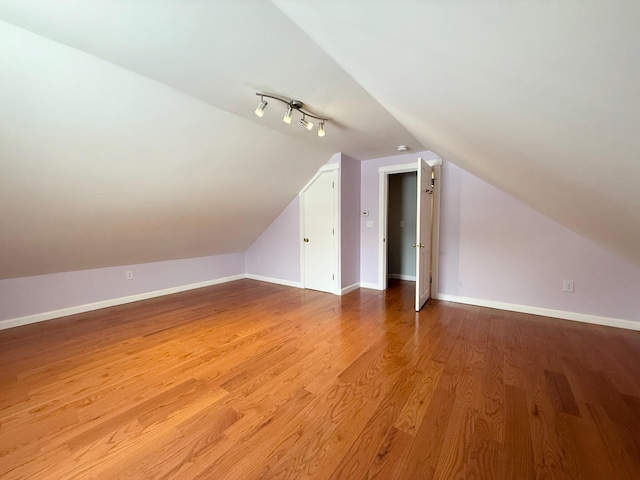 bonus room featuring lofted ceiling, wood finished floors, and baseboards