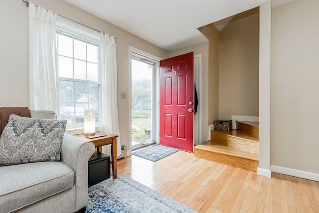 entrance foyer featuring baseboard heating, baseboards, and wood-type flooring