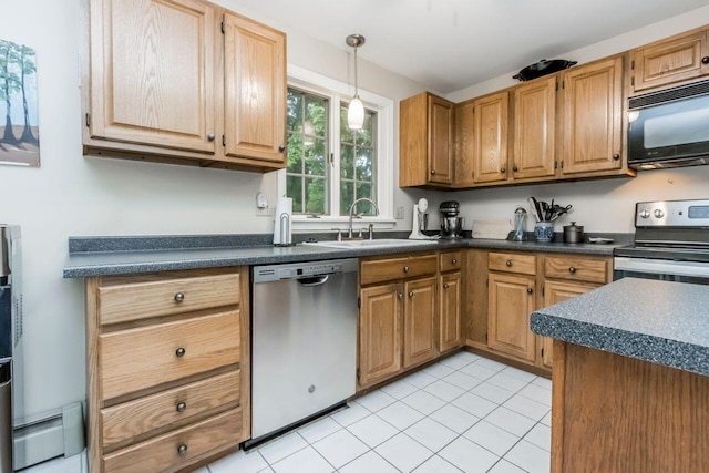 kitchen featuring dark countertops, hanging light fixtures, appliances with stainless steel finishes, and a sink