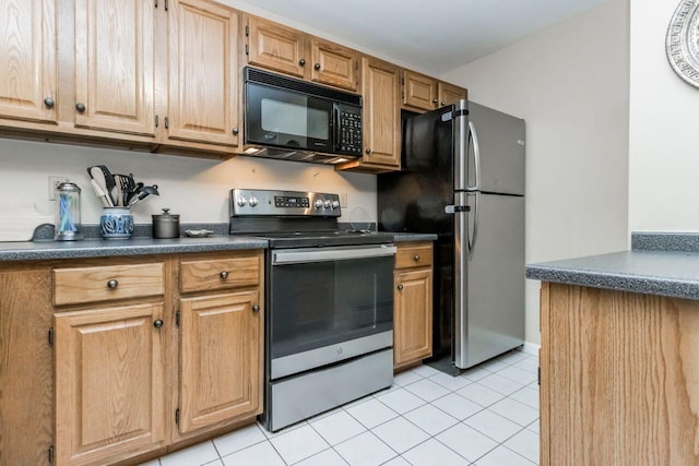 kitchen featuring dark countertops, light tile patterned floors, and appliances with stainless steel finishes