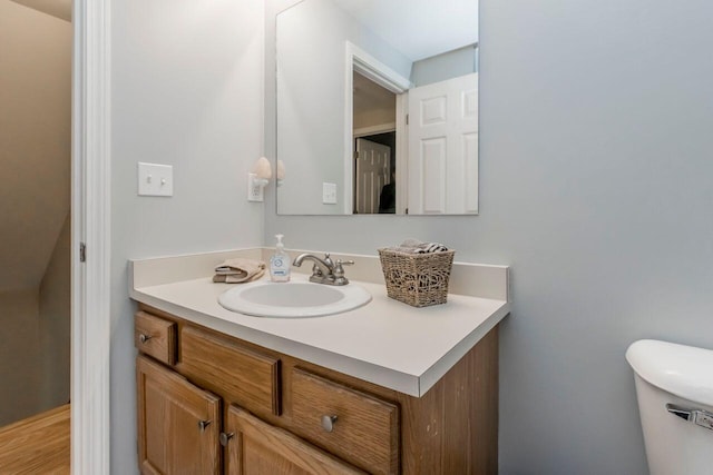 half bathroom featuring vanity and toilet