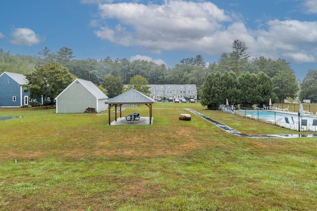 view of yard with a detached carport, a gazebo, a fenced in pool, and a patio