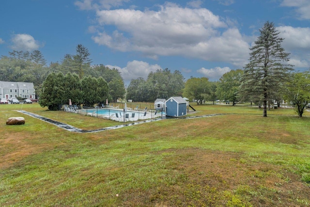 view of yard featuring an outdoor structure, fence, and an outdoor pool