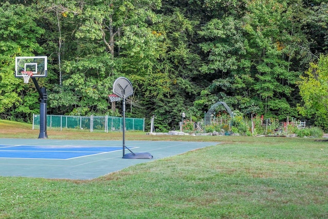 view of sport court featuring a yard, community basketball court, and fence