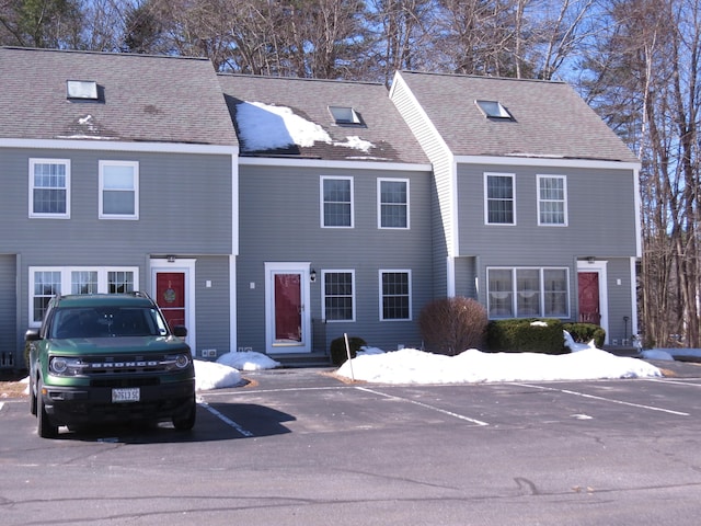 view of front of property featuring uncovered parking and a shingled roof