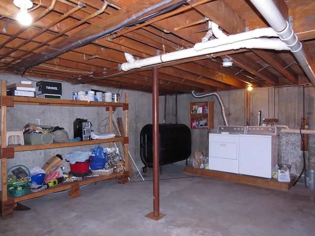 unfinished basement featuring washer and clothes dryer and heating fuel