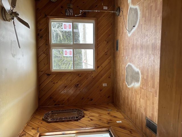 empty room with visible vents and wood walls