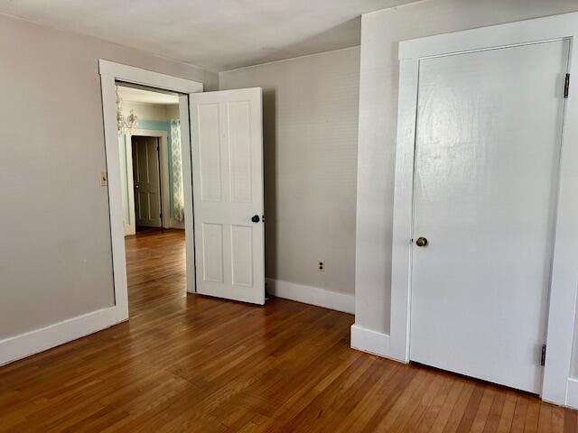 unfurnished bedroom with baseboards and wood finished floors