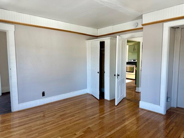 unfurnished bedroom featuring baseboards and wood finished floors